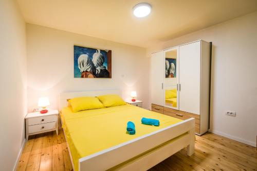 a bedroom with a yellow bed and a cabinet at Apartment Duci in Split