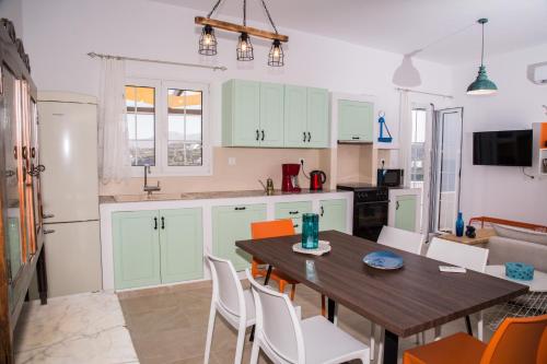 a kitchen with green cabinets and a table and chairs at Sunrise Bay in Panteli