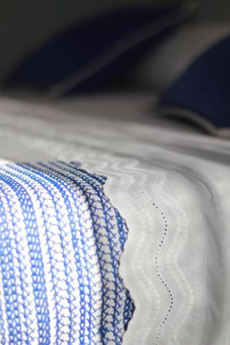 a close up of a white blanket on a bed at Calida B&B in Castellammare del Golfo