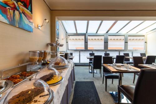 a restaurant with tables and chairs with food on display at MH Design Hotel in Naples