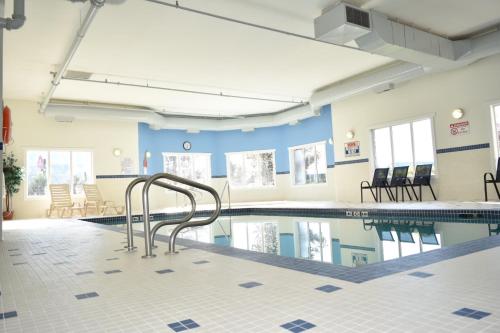a swimming pool with a metal railing in a building at Ramada Golden in Golden