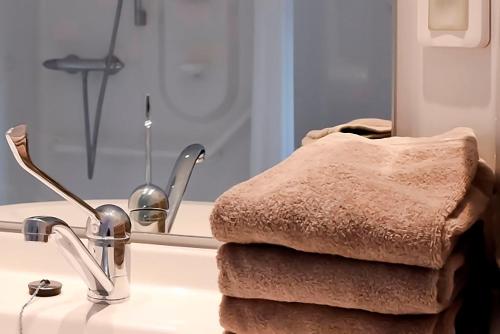 a bathroom sink with a towel next to a mirror at Côté Hôtel in Légny