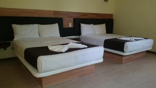 two beds in a hotel room with two bedsitures at Hotel Cañada Internacional in Palenque