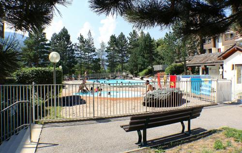 une clôture avec un banc en face d'une piscine dans l'établissement studio rose résidence Les Glières, à Bourg-Saint-Maurice