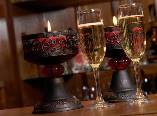 two glasses of champagne on a table with candles at Cilene del Faro Suites & Spa in Ushuaia