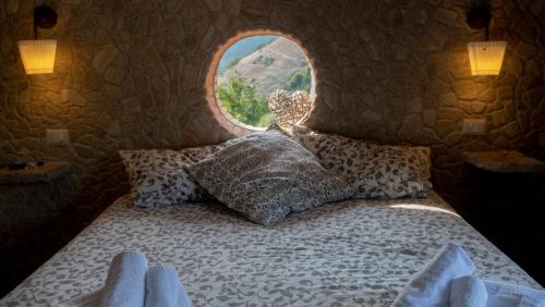 a bedroom with a bed with a round window at Guarda Che Luna in Sasso di Castalda
