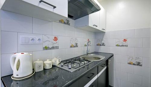 a white kitchen with a sink and a stove at studio Anulka in Zakopane