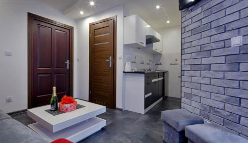a kitchen and a living room with a brick wall at studio Anulka in Zakopane