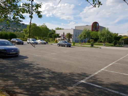 a parking lot with cars parked in front of a building at L'Abribis in Firminy