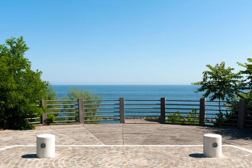 a patio with a view of the ocean at Hotel Alexander in Gabicce Mare