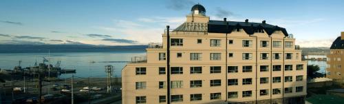 a large white building with a tower on top of it at Cilene del Faro Suites & Spa in Ushuaia