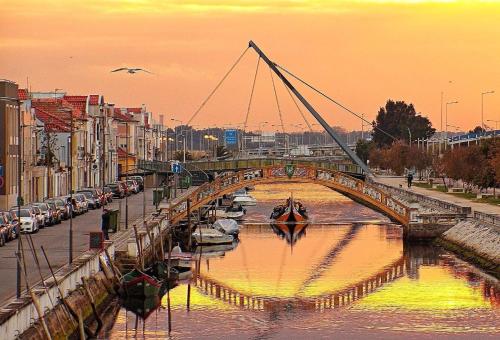 a bridge over a river with boats in a city at Sun, Sky and Sea in Esmoriz