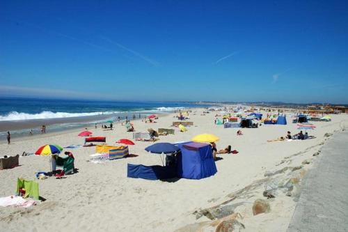 a group of people on a beach with umbrellas at Sun, Sky and Sea in Esmoriz