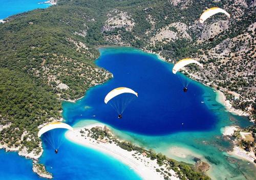 three paragliders flying over a body of water at Club Pink Palace Hotel in Oludeniz