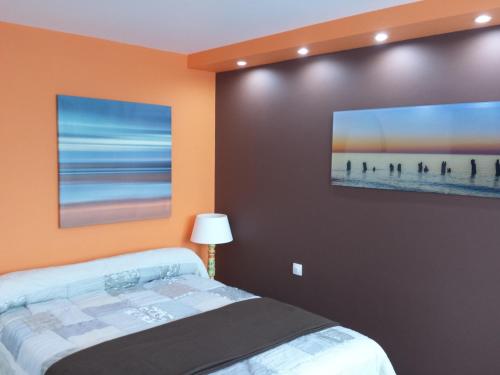 a bedroom with a bed and a painting on the wall at L'Abribis in Firminy