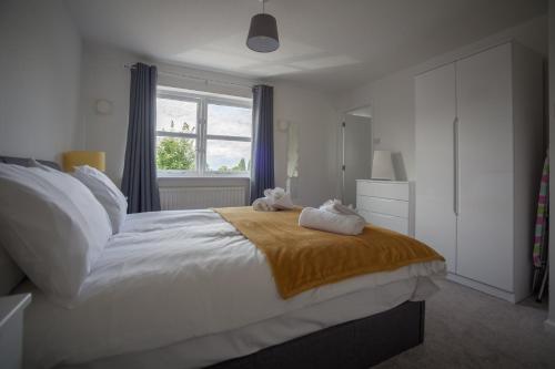 a bedroom with a large bed with two stuffed animals on it at Kestrel House by RentMyHouse in Hereford