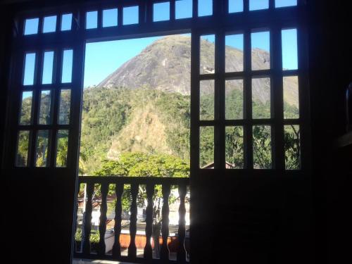 an open window with a view of a mountain at Apartamento Duplex no melhor bairro de NF in Nova Friburgo