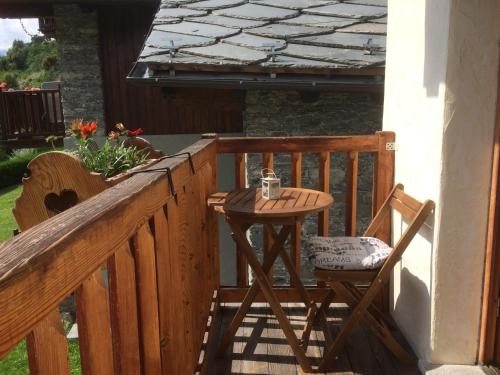 a wooden balcony with a table and two chairs at Chez Moillet in La Salle