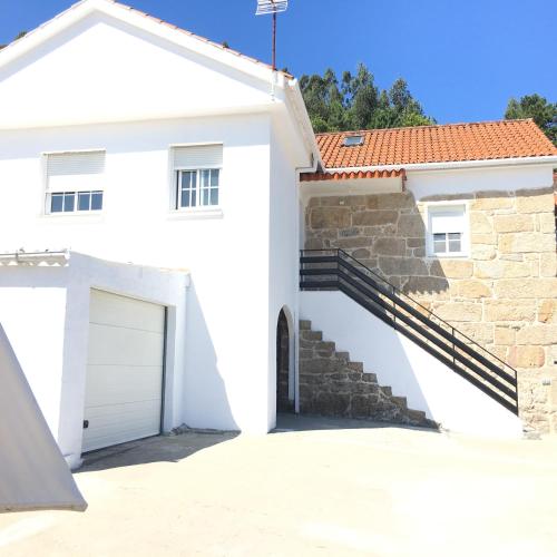 a white house with a garage at Casa CAMPELO- Playas de Pinténs - CANGAS-HIO- Ría de Aldán in Cangas de Morrazo