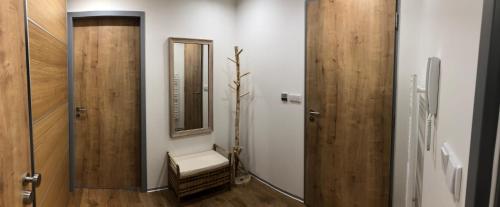 a hallway with a mirror and a chair in a room at Apartmán Jestřáb in Janske Lazne