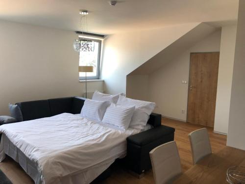 a bedroom with a bed with white sheets and a window at Apartmán Jestřáb in Janske Lazne