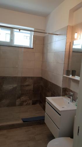a bathroom with a shower and a toilet and a sink at Sea Sound Apartment Mamaia Nord in Mamaia Sat/Năvodari