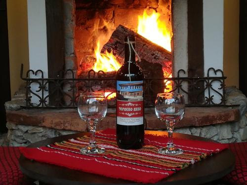 コプリフシティツァにあるOnce upon a timeのワイン1本、暖炉の前のテーブルにグラス2杯