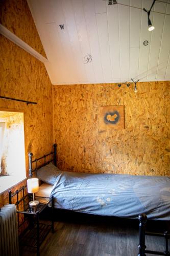 a bedroom with a bed with a blue sheets at The BlackSmith's House in Libin