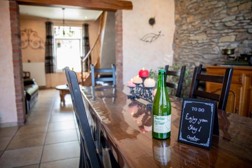 a bottle of wine sitting on a wooden table at The BlackSmith's House in Libin