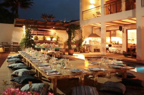 a long wooden table with plates and wine glasses at Barracuda Boutique in Itacaré