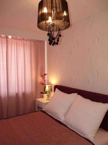 a bedroom with a bed and a chandelier at Apartament Hevelius in Zamość