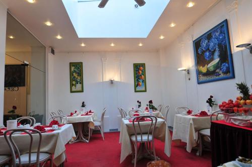 a restaurant with white tables and chairs and a ceiling at Cerano City Hotel Köln am Dom in Cologne