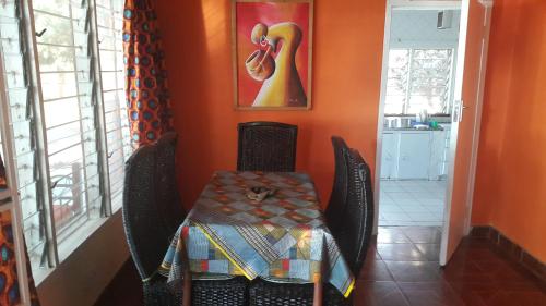 a dining room with a table and chairs and a painting at Villa Liwonde - Cottage in Liwonde
