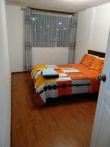 a bedroom with a bed in a room with a window at Jorge's apartment in Baños