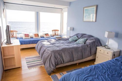 a bedroom with two beds and a large window at Cabañas Barlovento in San Carlos de Bariloche