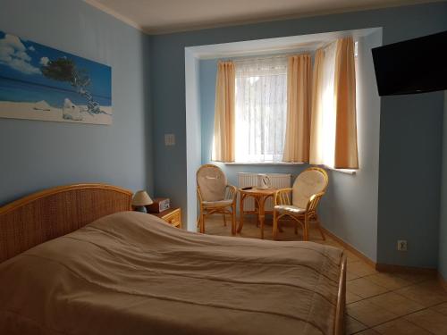 a bedroom with a bed and a table and chairs at Posejdon in Ustronie Morskie