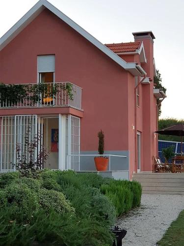 a pink house with a balcony and a patio at Alto Belo in Felgueiras