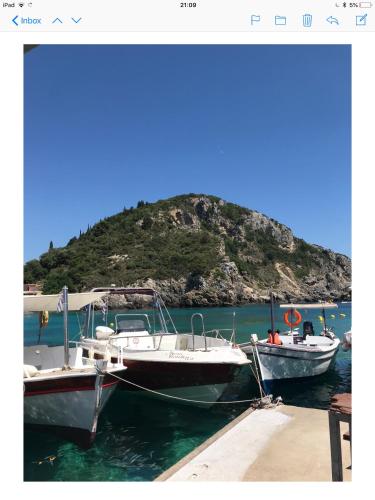 two boats are docked at a dock in the water at Villa Ampelaki 2 in Paleokastritsa
