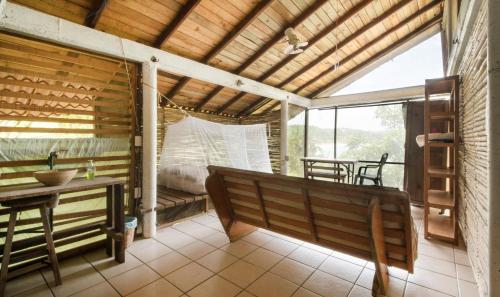 a porch with a bench and a table and a dining room at La pajarera in Mazunte