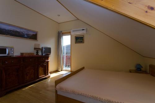 1 dormitorio en el ático con cama y ventana en Love Island Guesthouse, en Druskininkai