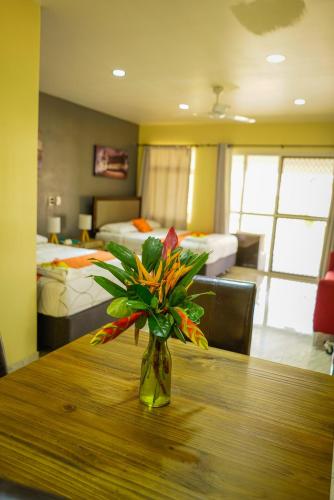 a vase of flowers sitting on a table in a bedroom at Samoana Boutique Hotel in Apia