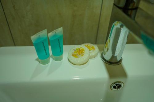 a sink with two toothbrushes and two cups on it at Samoana Boutique Hotel in Apia
