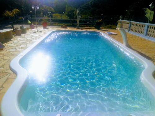 a large swimming pool with blue water at night at Pousada 7 Estrelas in Ipiabas