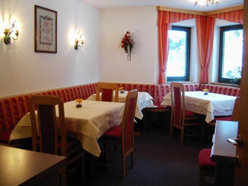 ein Restaurant mit zwei Tischen und Stühlen und zwei Fenstern in der Unterkunft s'Jechlas in Sölden