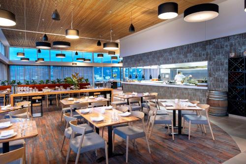 un restaurante con mesas y sillas y un bar en Peppers Silo en Launceston