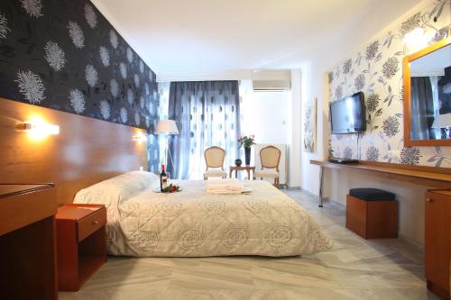 a hotel room with a bed and a television at Hotel Mallas in Nea Kalikratia