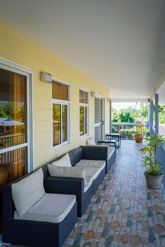a patio with couches and tables on a building at Samoana Boutique Hotel in Apia