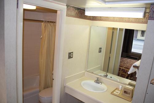 uma casa de banho com um lavatório, um WC e um espelho. em Budget Host Inn Bristol em Bristol