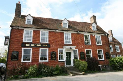 a red brick building with the fireplace inn at The George Inn in Robertsbridge