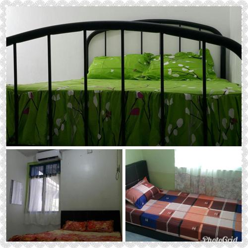 a bedroom with a bed with green comforter at DIDIE HOMESTAY 1 in Tanah Merah